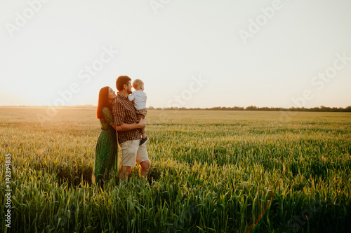 Happy family father and mother and child son  walking on nature at sunset
