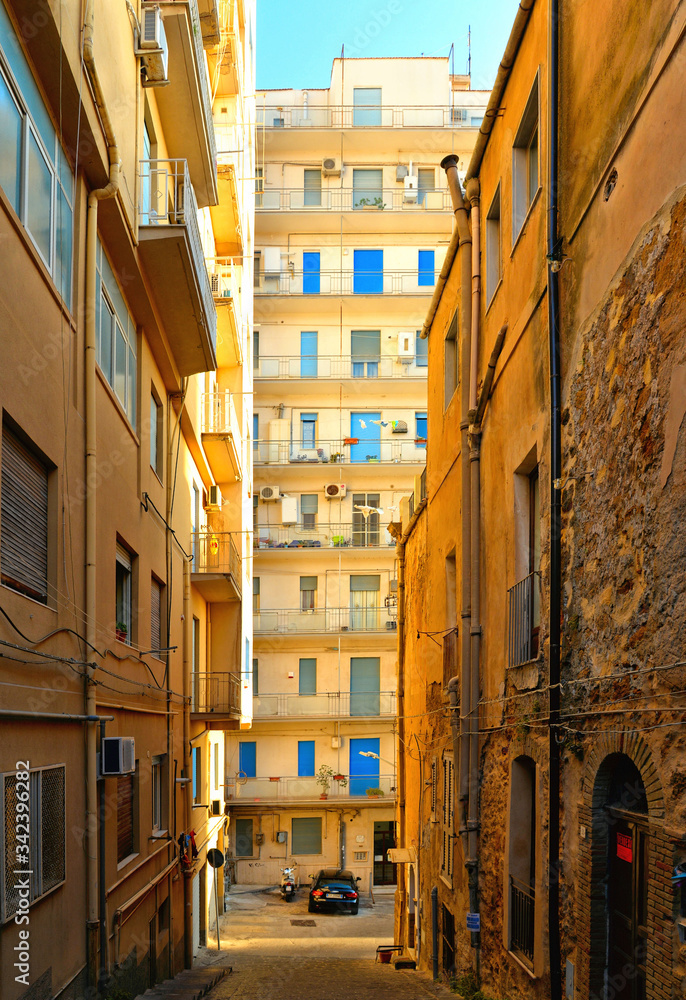 View of a narrow street with steps, old buildings and facades in the historical city of Agrigento in Sicily, Italy