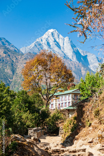 Traditional nepalese guesthouse with mount Numbur on the way to Nurning. Trekking in Nepal Himalayas. EBC (Everest base camp trek) trail lower part from Jiri to Lukla part of Everest trek. Nepal. photo