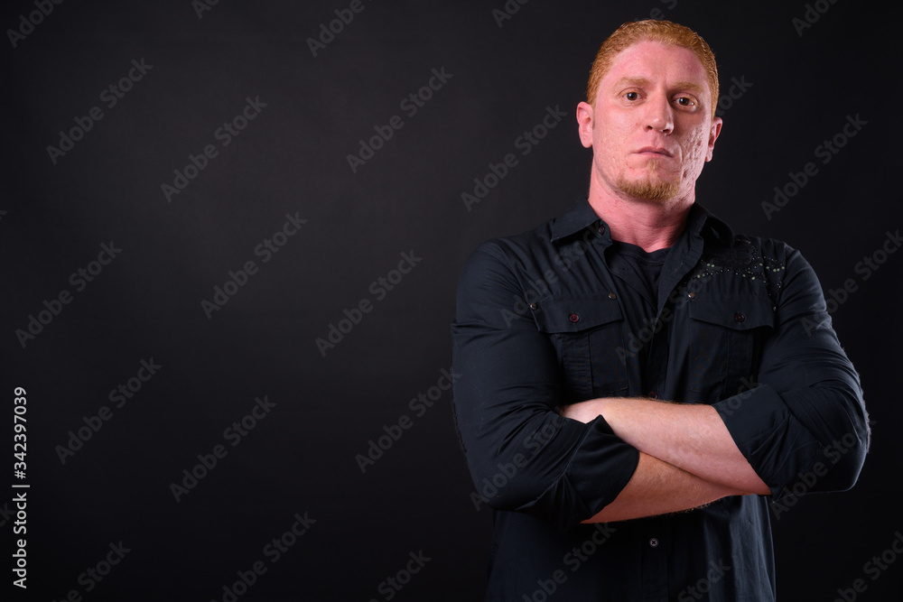Portrait of muscular man with orange hair looking confident