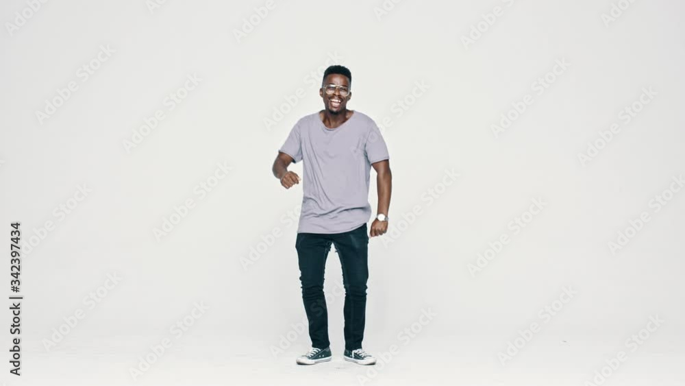 African man in eyeglasses dancing on white background. Full length of a happy black guy showing some dance moves.
African man in eyeglasses dancing on white background. Full length of a happy black guy showing some dance moves.