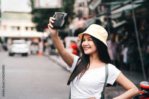 Traveller woman selfie photo with instant camera. © dodotone