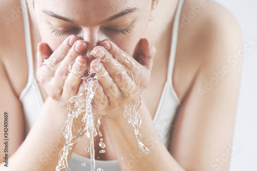 Photography Close-up portrait of a happy girl washing her face with water splashes in white underwear