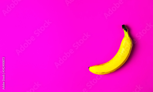 One ripe yellow banana on a bright red paper background. Flat lay, copy space