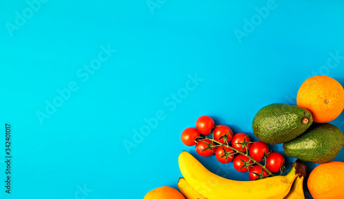 Fototapeta Naklejka Na Ścianę i Meble -  Various healthy fruits on a bright blue background. Flat lay, with copy space for text. Grocery online store, delivery of products on order or donation