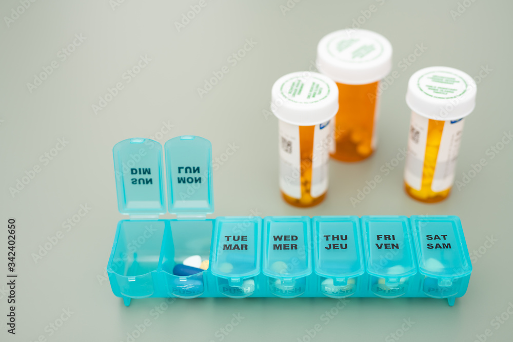 Orange Pill Bottles and Blue Pill Dispenser on Table
