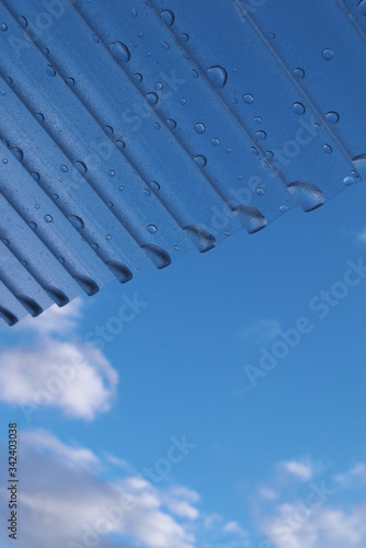                                   - Corrugated plastic roof and water droplets with blue sky background