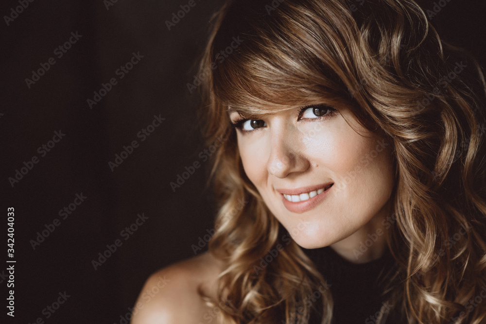 Portrait of a beautiful woman 36 years old with curly hair and an open playful smile and white teeth. Soft selective focus. Portrait of a beautiful woman 36 years old with curly hair and an open playful smile and white teeth. Soft selective focus.