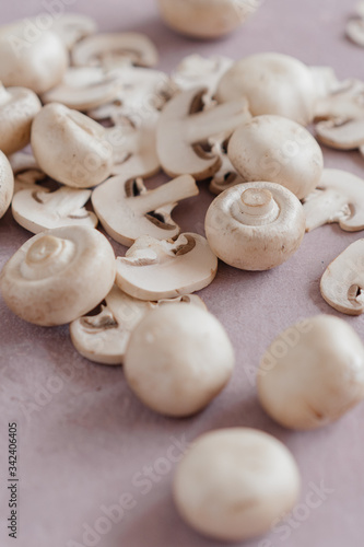 whole mushrooms and sliced ​​on a light pink background
