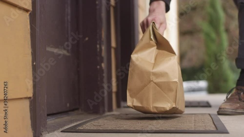 No contact home food delivery order left on a doorstep for the customer to pick up photo