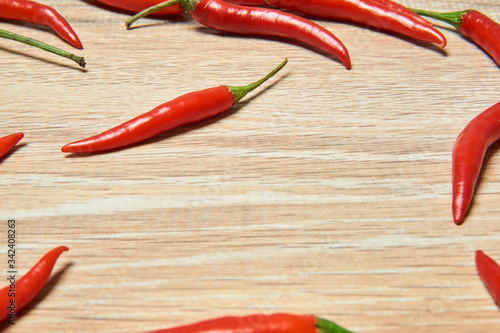 pods of red chili peppers laid out on a wooden surface for drying