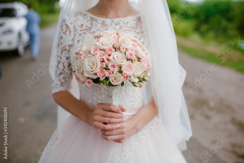 female hands hold the bride’s wedding bouquet, close-up