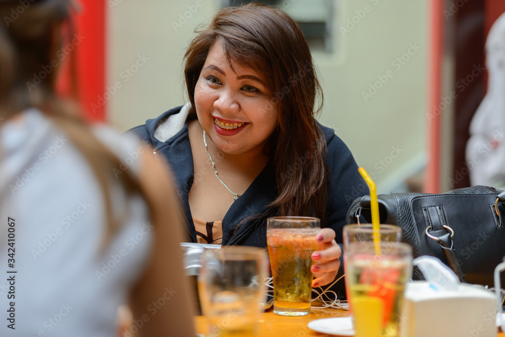 Happy young Asian women as friends at the coffee shop outdoors Happy young Asian women as friends at the coffee shop outdoors