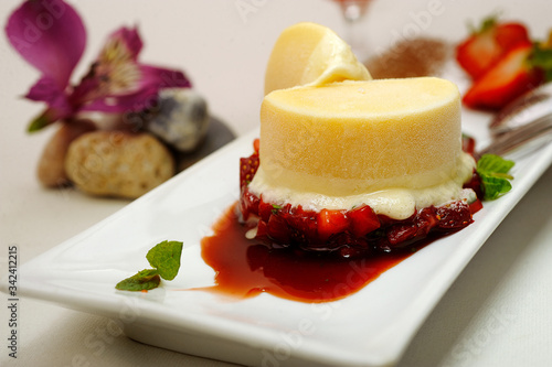yellow ice cream with strawberries and mint leaves