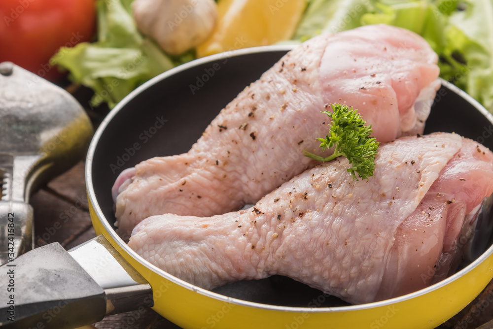 Raw chicken fillet with garlic, pepper and spicy on a wooden background Raw chicken fillet with garlic, pepper and spicy on a wooden background