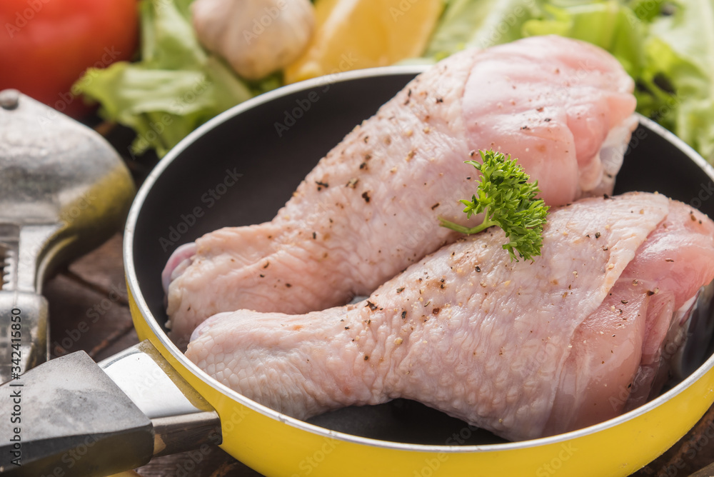 Raw chicken fillet with garlic, pepper and spicy on a wooden background Raw chicken fillet with garlic, pepper and spicy on a wooden background