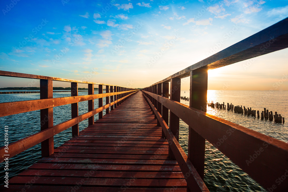 Bridge and sunset,Beautiful wooden red long bridge with sunset at samut sakhon province,Thailand is a dolphin view point called mutshanu shring