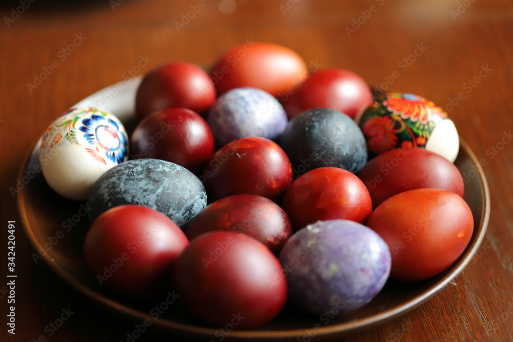 Easter painted eggs on a plate, purple, red, maroon, blue, black eggs, Easter traditions Easter painted eggs on a plate, purple, red, maroon, blue, black eggs, Easter traditions