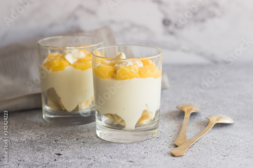 Tasty lemon dessert in a glass. Lemon dessert with biscuit, white chocolate and lemon curd