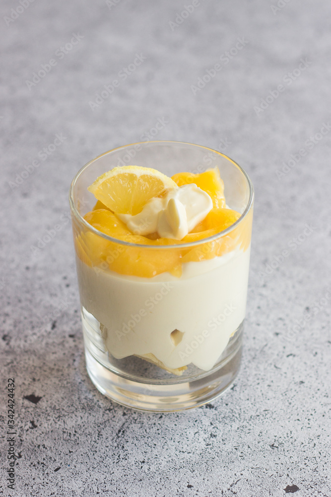 Tasty lemon dessert in a glass. Lemon dessert with biscuit, white chocolate and lemon curd Tasty lemon dessert in a glass. Lemon dessert with biscuit, white chocolate and lemon curd