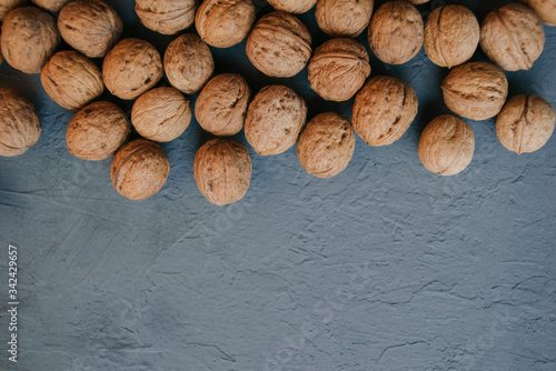 walnut on a concrete blue background scattered randomly, wholesome and natural food