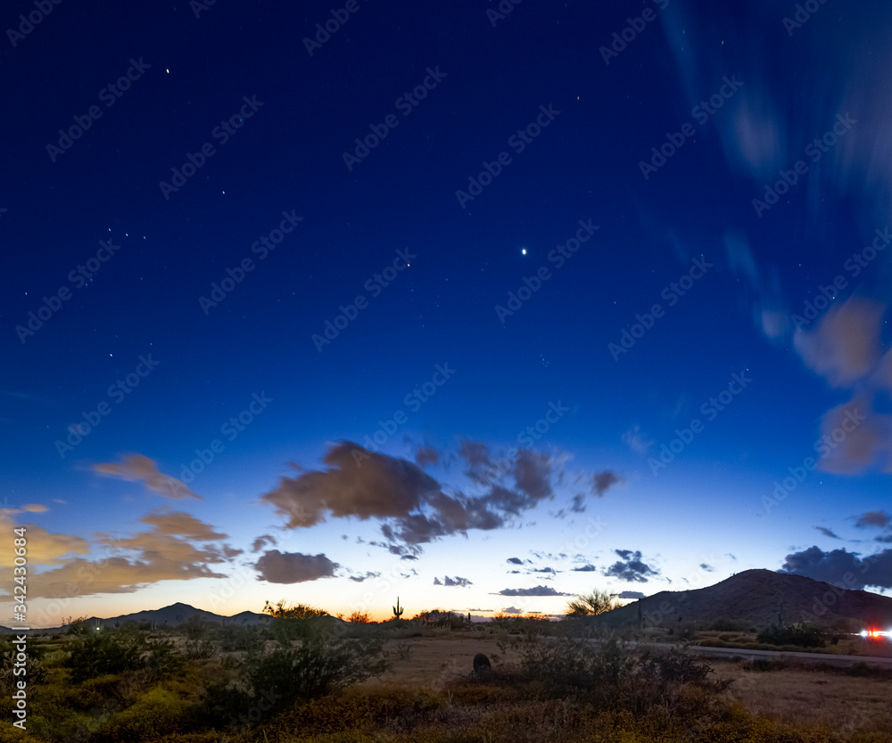 Evening image of the desert night sky during the blue hour with dramatic clouds and stars