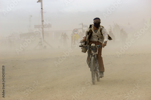 Man in a desert dust storm on a bicycle © ann gadd