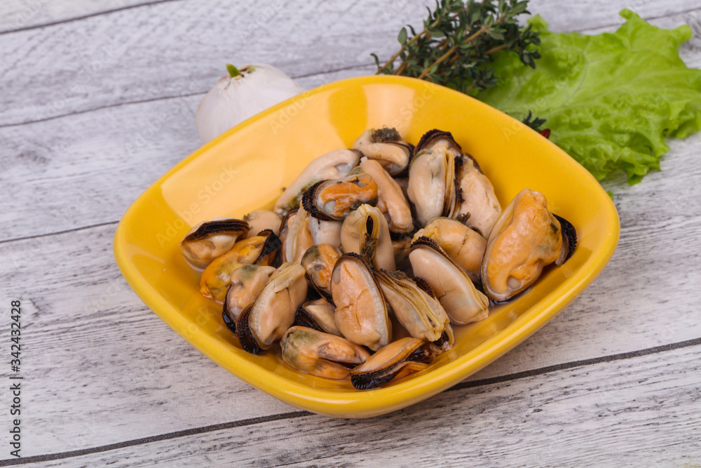 Pickled mussels in the bowl served pepper, garlic and salad Pickled mussels in the bowl served pepper, garlic and salad