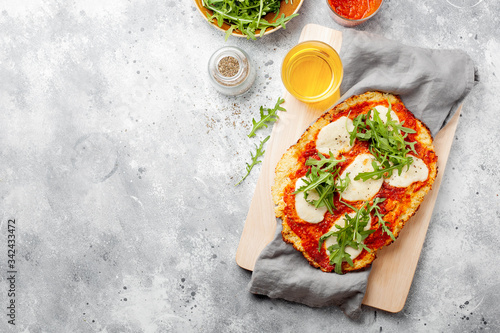 Homemade gluten-free Cauliflower pizza crust dough with tomatoes marinara sauce,mozzarella cheese for low-carb and keto diet.Top view,copy space