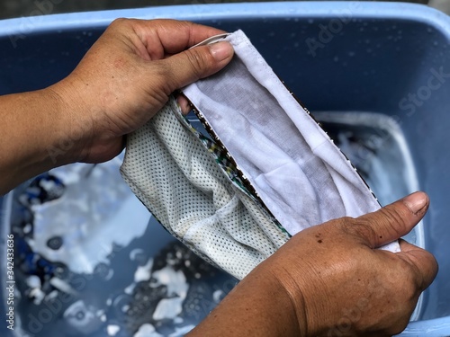 Cotton cloth mask soak in blue tank after the used and washing,natural glare light,the mask repeated use 2-3 times,after use every day should wash and dry in the sun to be sterilized as well.