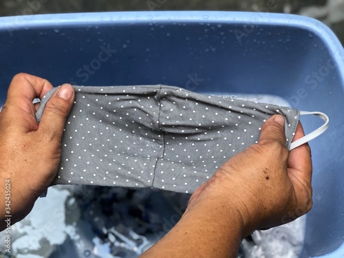 Cotton cloth mask soak in blue tank after the used and washing,natural glare light,the mask repeated use 2-3 times,after use every day should wash and dry in the sun to be sterilized as well.