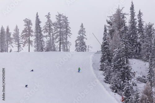 skiers descend from a slope in Slovakia in winter, ski resort