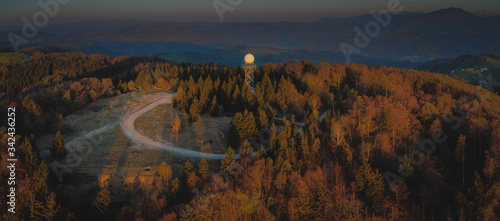 Aerial drone panorama view of a rain radar or meteorological doppler radar for measuring precipitation in early morning hours during sunrise on Pasja Ravan hill in Slovenia