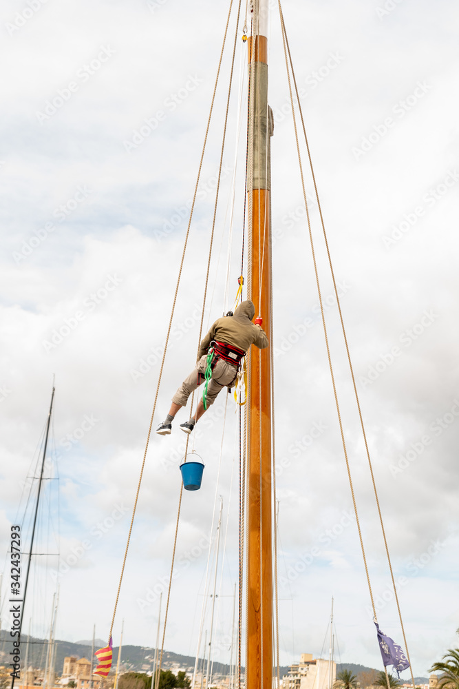 Arbeiten an dem Mast eines Segelschiffs in einem Spanischen Hafen Arbeiten an dem Mast eines Segelschiffs in einem Spanischen Hafen