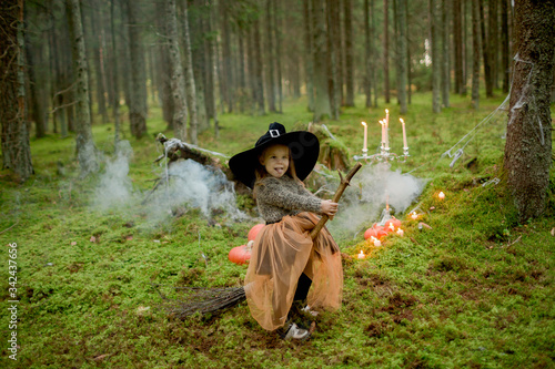 little girl witch on a broomstick for halloween © Anastasiya Krychun
