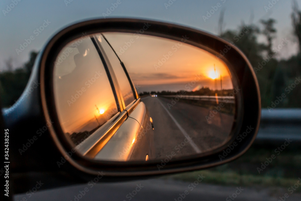 Sunset reflection in the car mirror in summer
