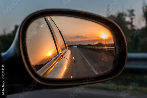 Sunset reflection in the car mirror in summer