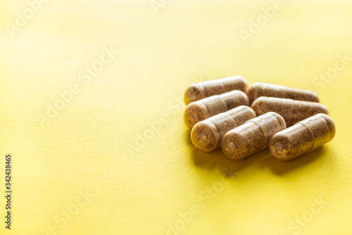 Vitamin pills on a yellow background