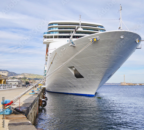 Modern white Costa Cruises cruiseship or cruise ship liner Costa NeoRomantica in port of Messina, Italy on Island of Sicily during Mediterranean summer cruising with harbor and ships and entrance photo