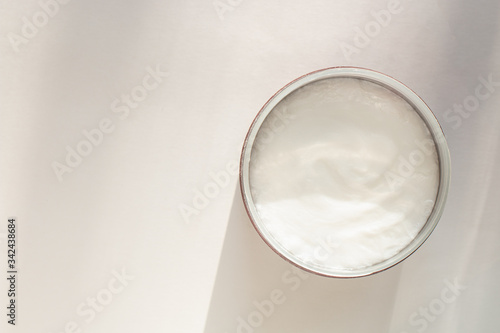 cream in a jar on a white background with shadows