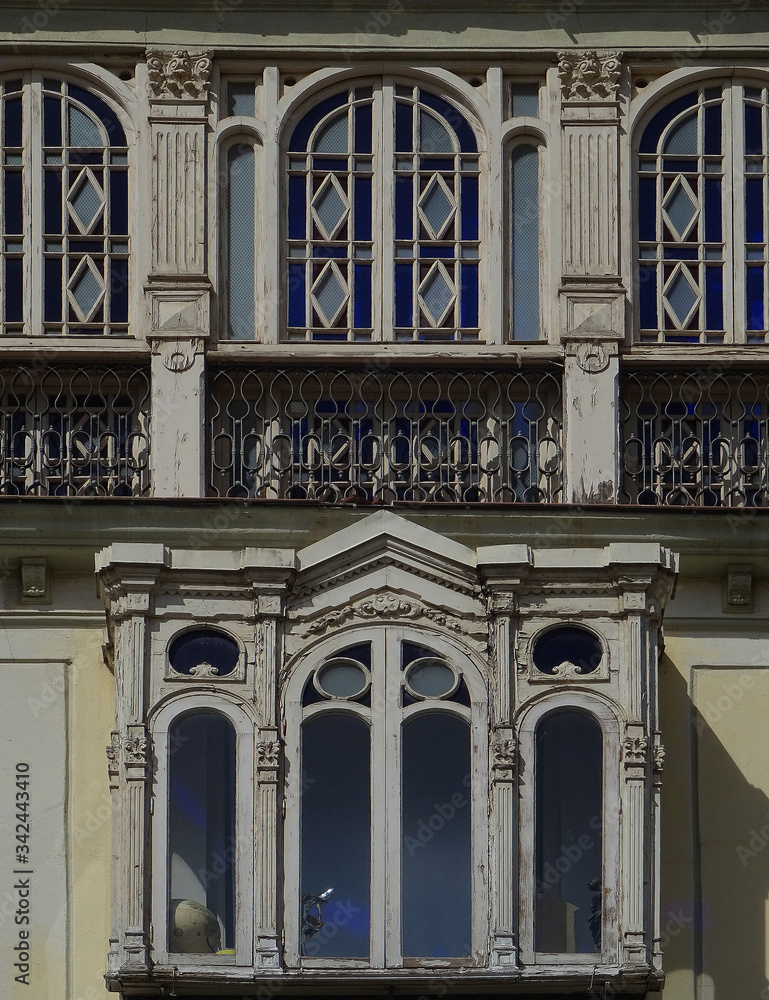 Revival building with beautiful enclosed glazed balconies in the old city center of Malaga. Spain.