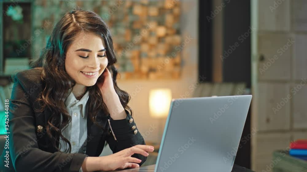 In the main office attractive lady manager working concentrated on her laptop she typing some documents in the dark office studio In the main office attractive lady manager working concentrated on her laptop she typing some documents in the dark office studio