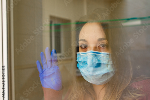 Girl looking out the window with face mask