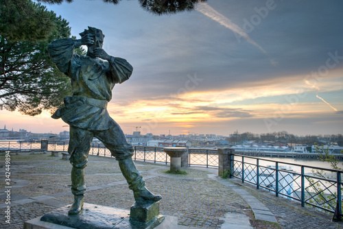 Statue de bronze devant le panorama du centre-ville de Nantes en France au premier rayon du soleil photo