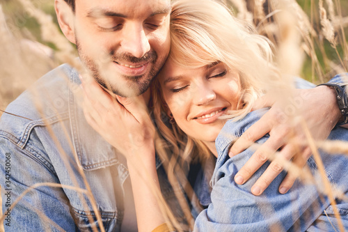 Canvas Print Blissful young couple relaxing in the field