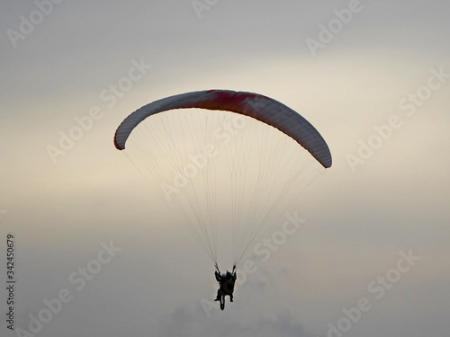 Paraglider flying wing in morning mist