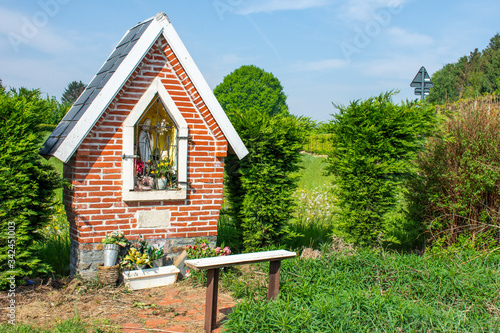 Foto Small Holy Mary chapel in the fields  with bench, in Overijse, Flanders, Belgium