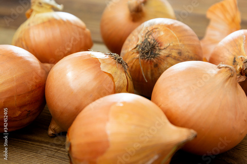 Fresh onion vegetable bulbs on wooden background.