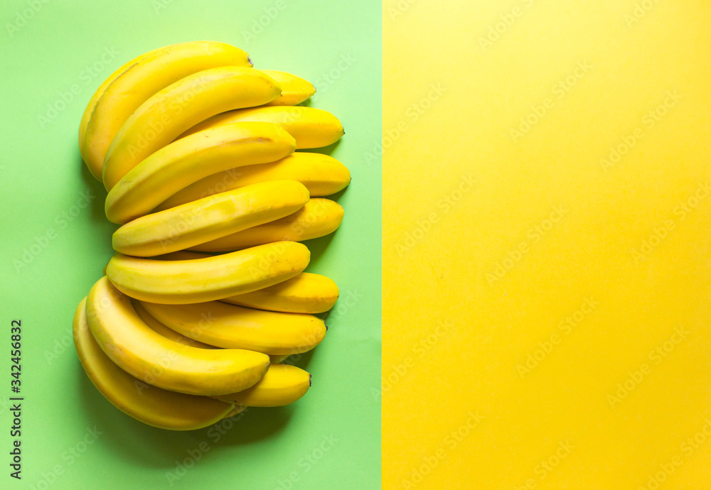 beautiful, fresh, bunch of yellow bananas on the yellow background. Concept of fresh food. Fruits offers as advertising or web background. Free copy space. Top view beautiful, fresh, bunch of yellow bananas on the yellow background. Concept of fresh food. Fruits offers as advertising or web background. Free copy space. Top view