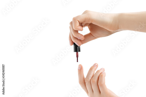 Woman covers her nails with red nail polish. Isolated on white background.